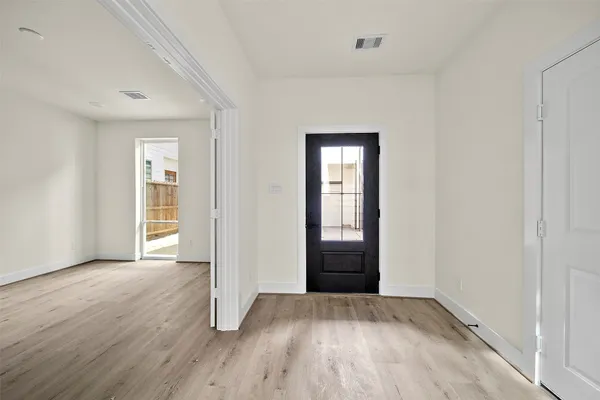 a view of an empty room with wooden floor
