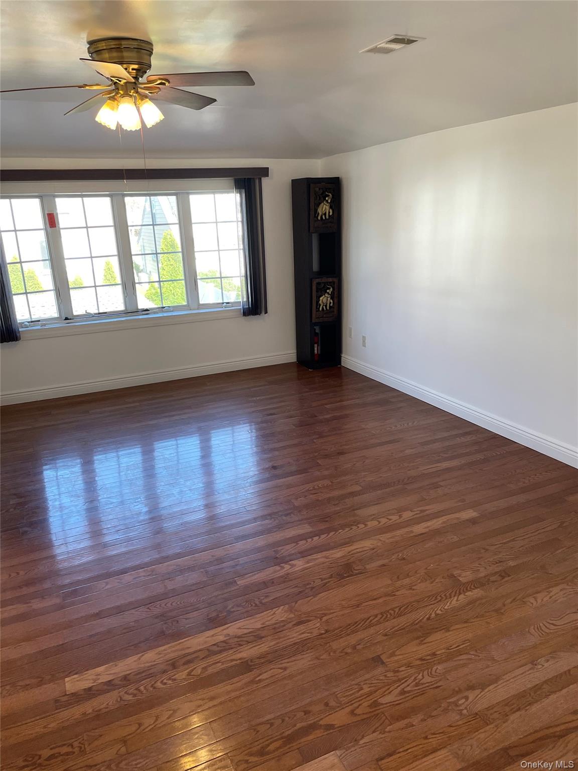 64-57 230th Street Queens, NY 11364 - Photo 3 of 7 a view of an empty room with window and wooden floor