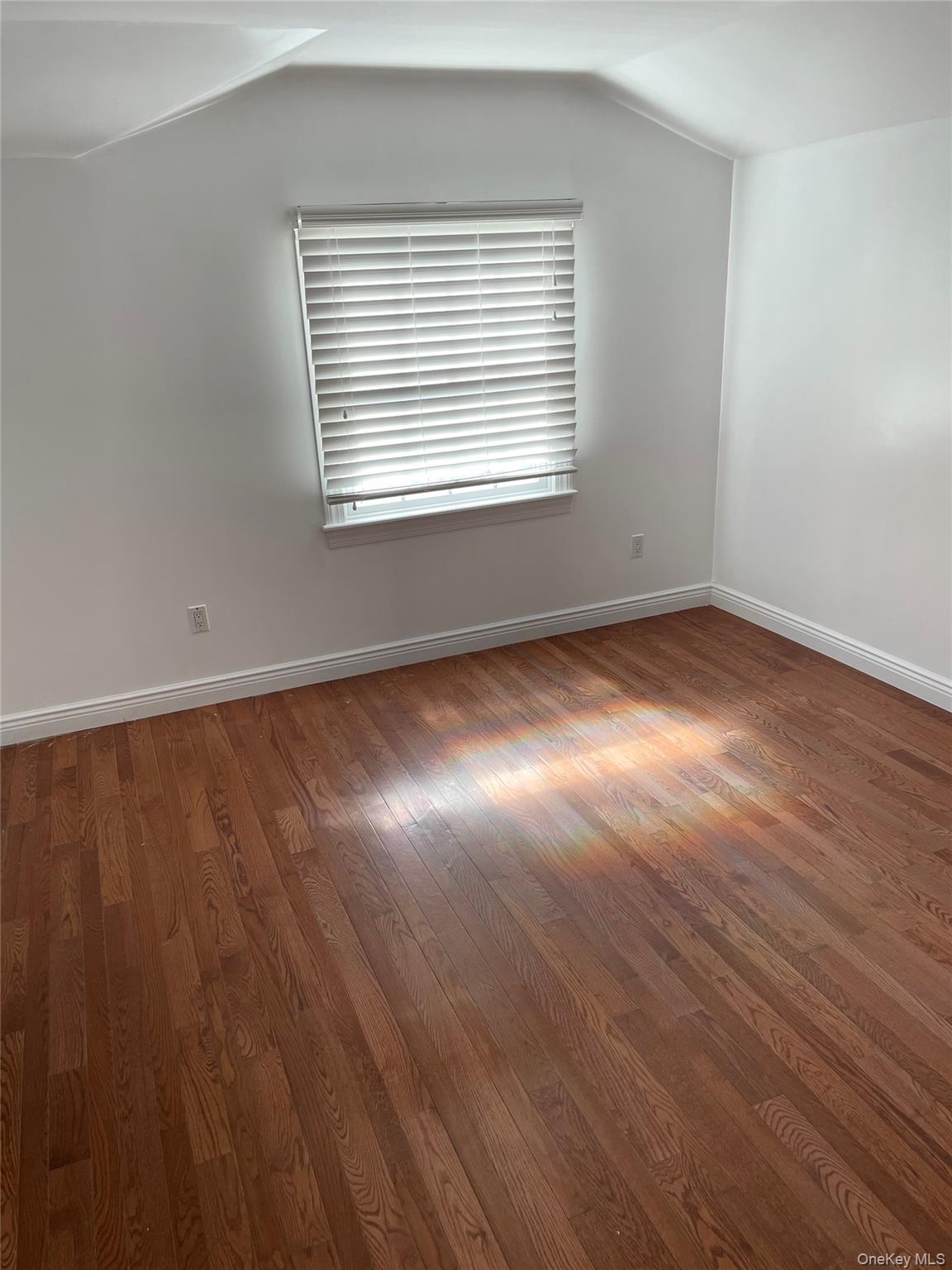 64-57 230th Street Queens, NY 11364 - Photo 5 of 7 an empty room with wooden floor and windows