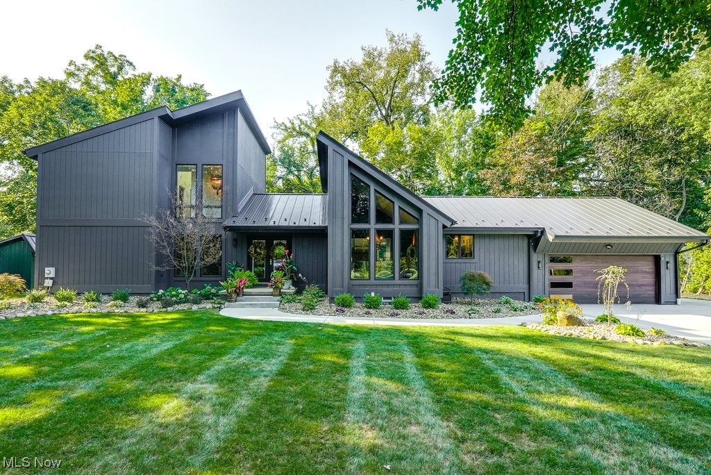 View of front of property with a garage and a front lawn