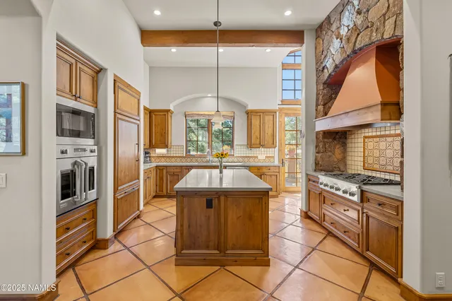 a kitchen with stainless steel appliances granite countertop a refrigerator and a stove top oven