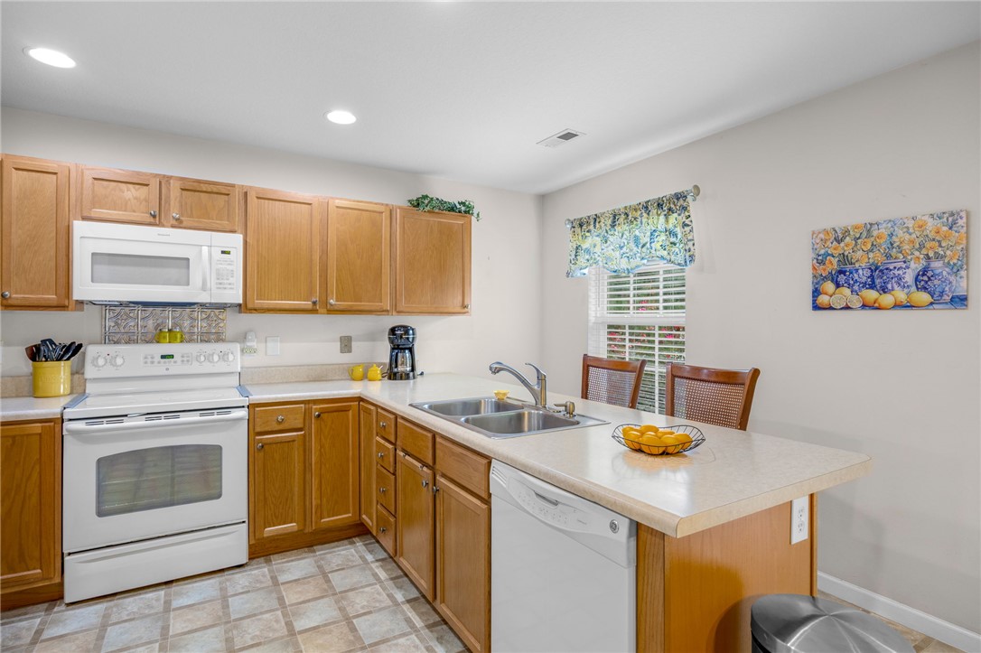125 Patagonia Road Anderson, SC 29625 - Photo 10 of 36 Ample wooden cabinetry and integrated breakfast bar seating define this functional kitchen layout.