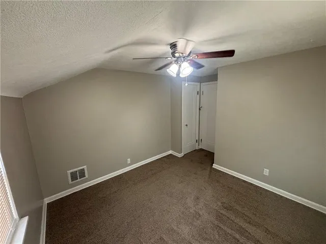 an empty room with a fan and a fan