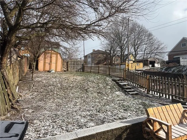 a front view of a house with a large tree