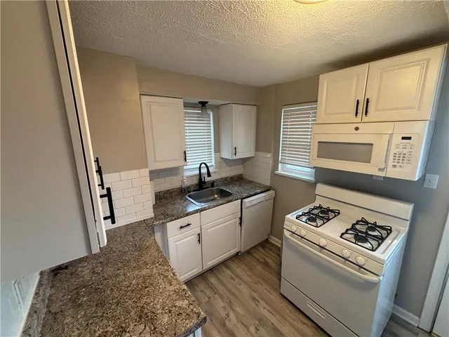 a kitchen with stainless steel appliances granite countertop a stove and a sink