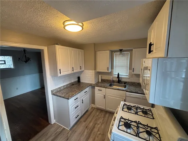 a kitchen with stainless steel appliances a sink stove and cabinets