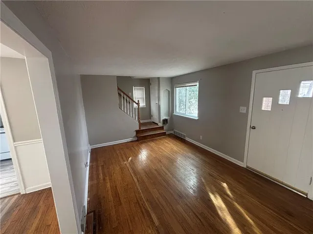 wooden floor in an empty room with a window