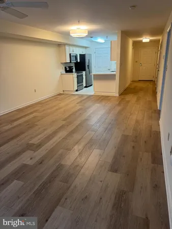 a view of empty room with wooden floor