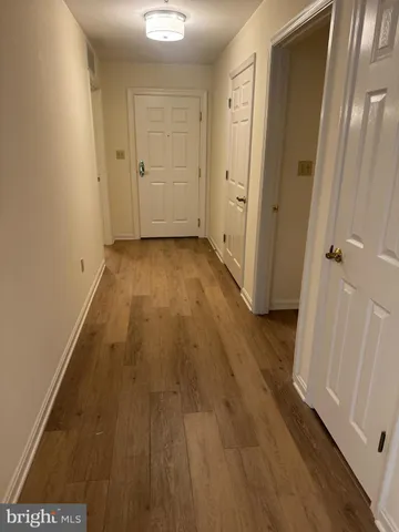 a view of a room with wooden floor and a bathroom