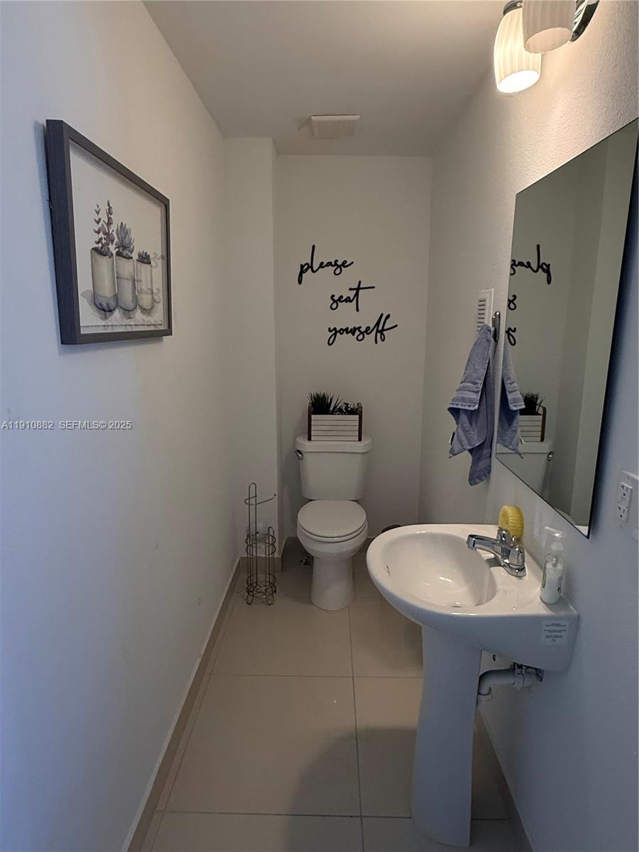 25855 Southwest 139th Court Homestead, FL 33032 - Photo 13 of 23 a bathroom with a toilet a sink and mirror