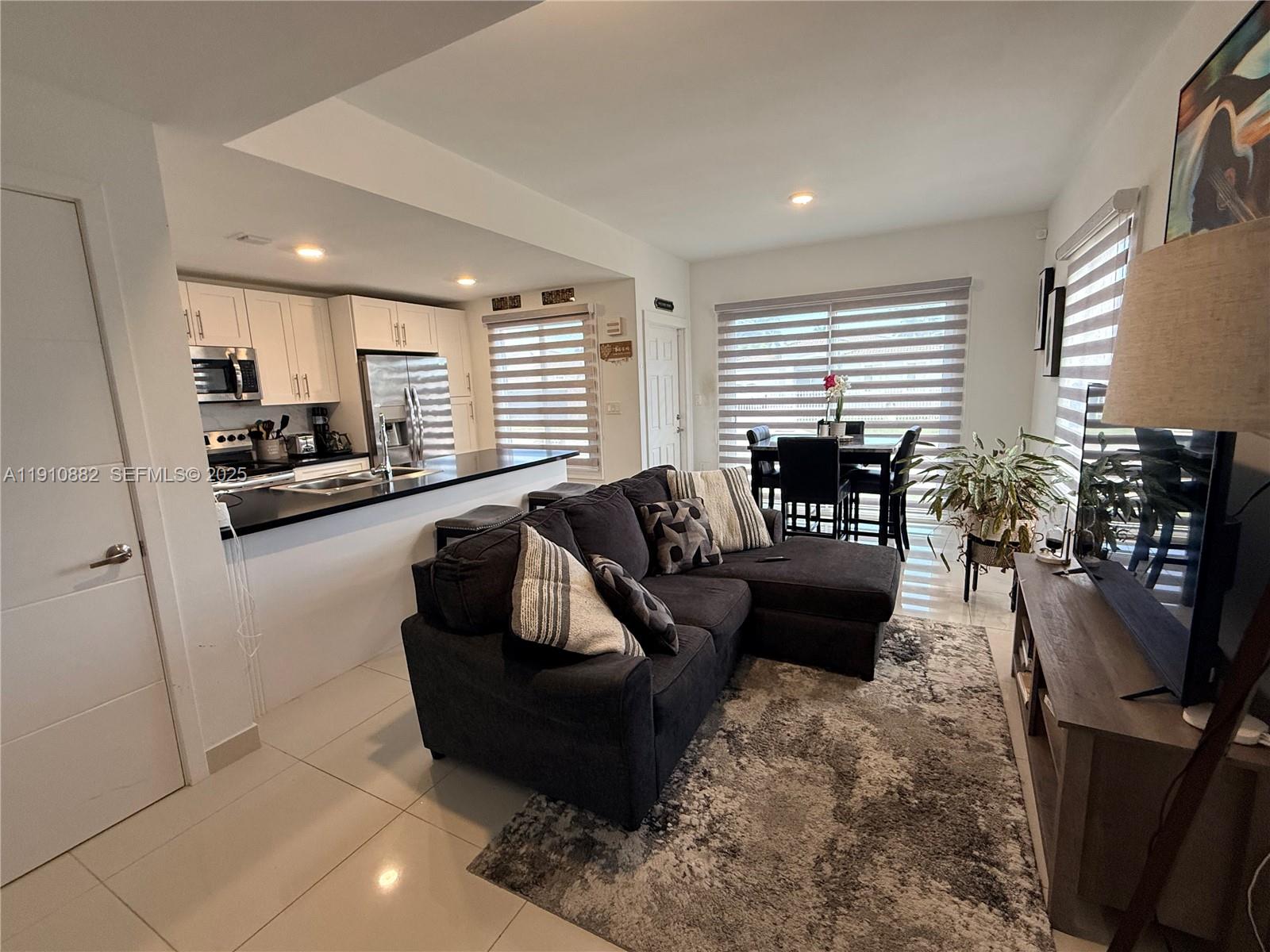25855 Southwest 139th Court Homestead, FL 33032 - Photo 3 of 23 a living room with furniture floor to ceiling window and flat screen tv
