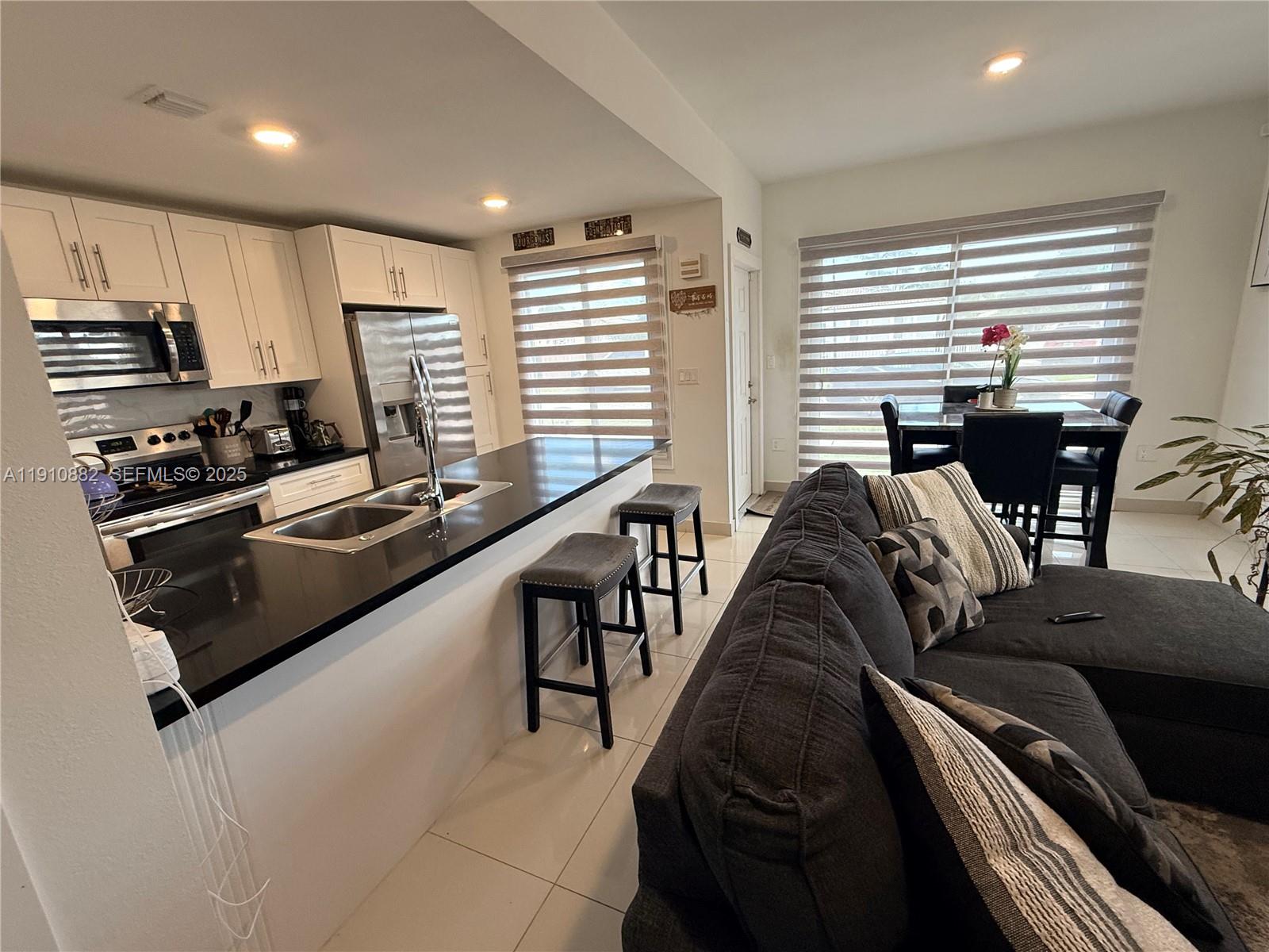 25855 Southwest 139th Court Homestead, FL 33032 - Photo 4 of 23 a living room with furniture a flat screen tv and kitchen view