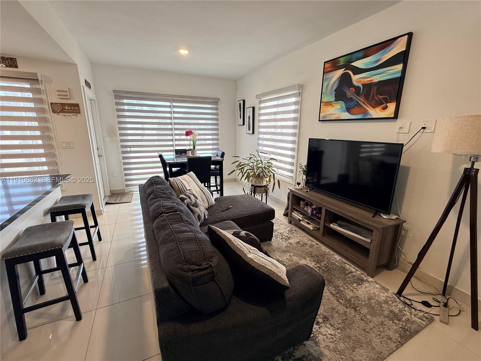 25855 Southwest 139th Court Homestead, FL 33032 - Photo 5 of 23 a living room with furniture a flat screen tv and a window