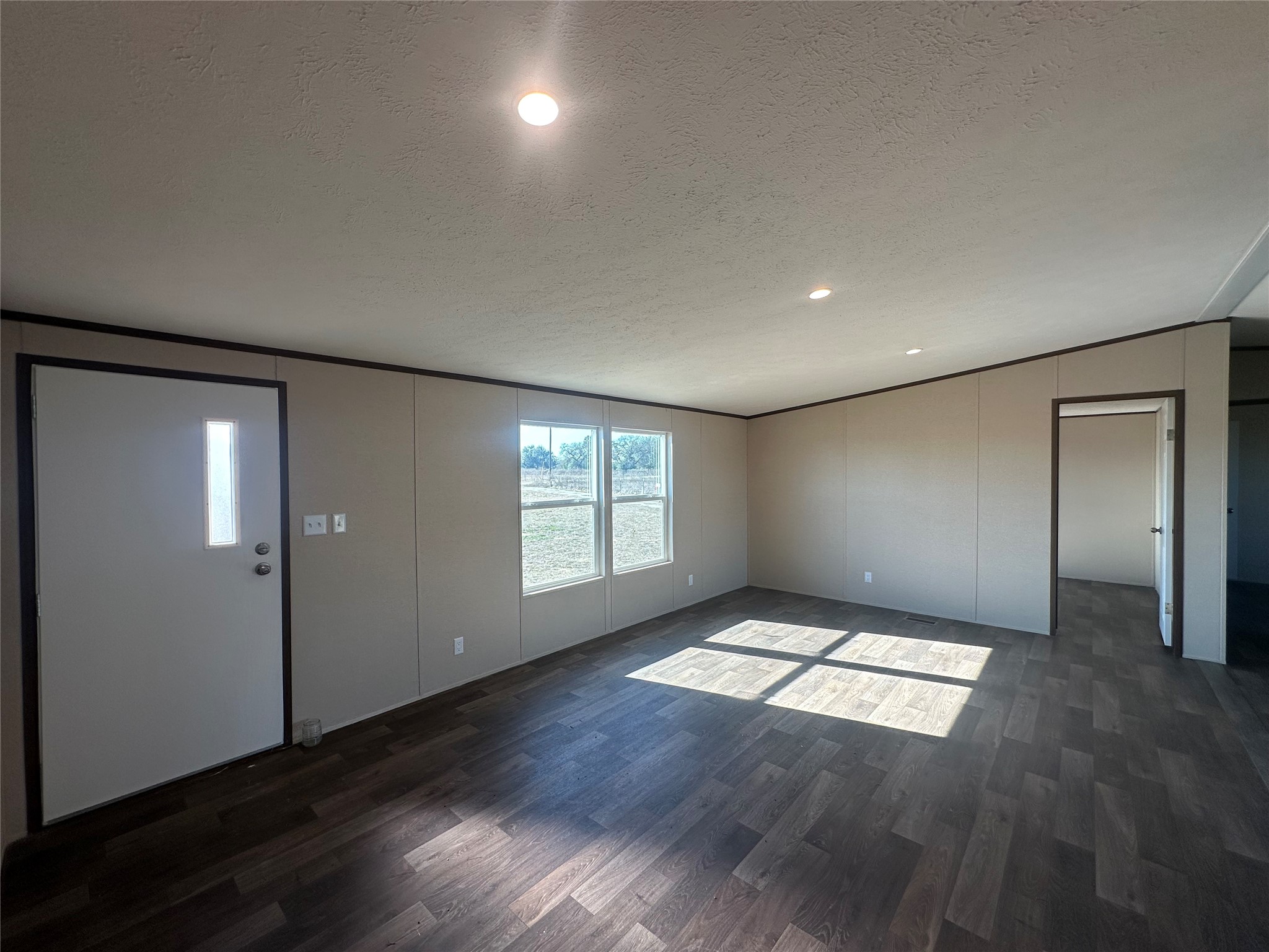 873 Golden Buffalo, TX 75831 - Photo 5 of 12 an empty room with wooden floor and windows