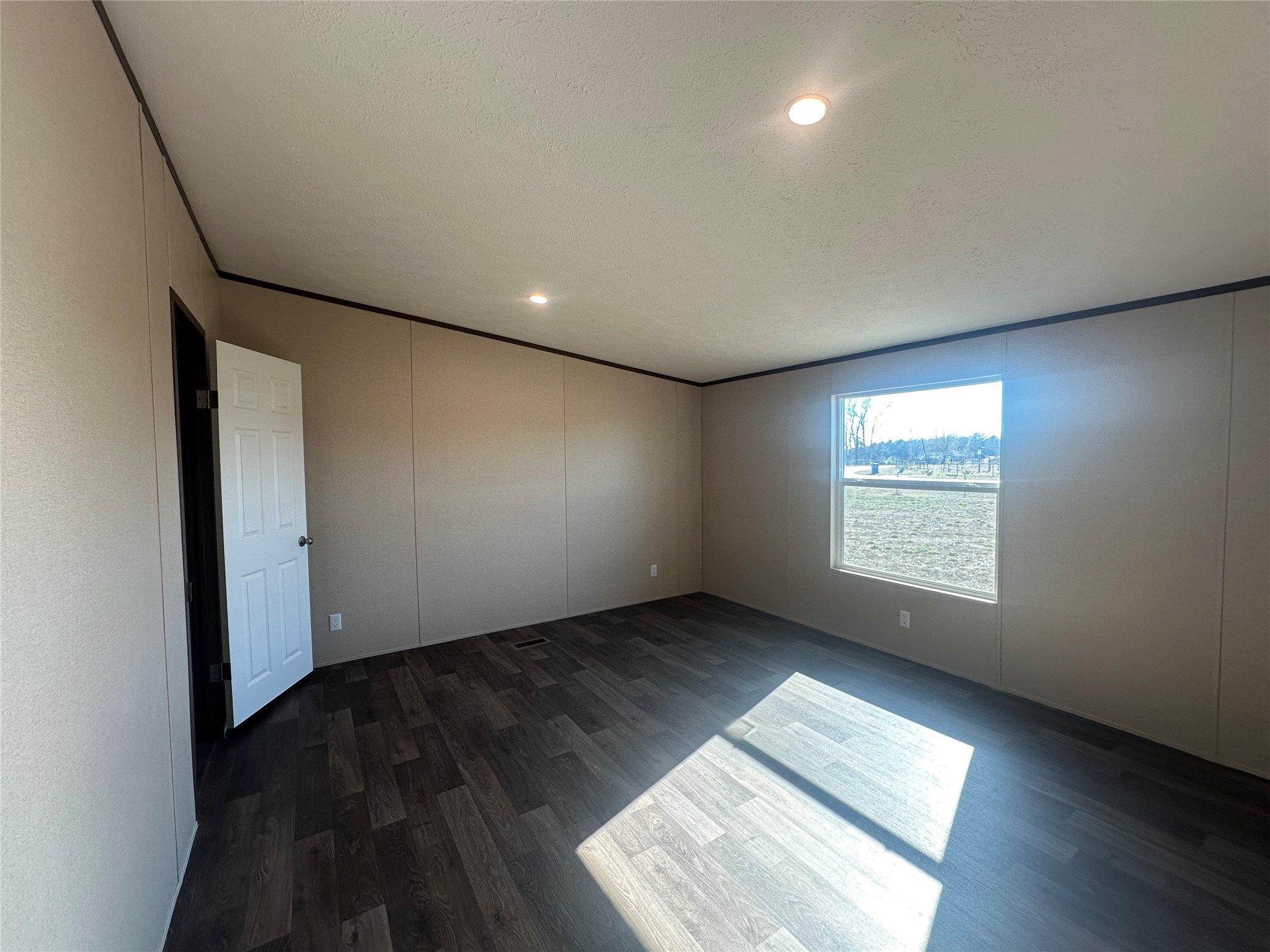 873 Golden Buffalo, TX 75831 - Photo 9 of 12 an empty room with wooden floor and windows