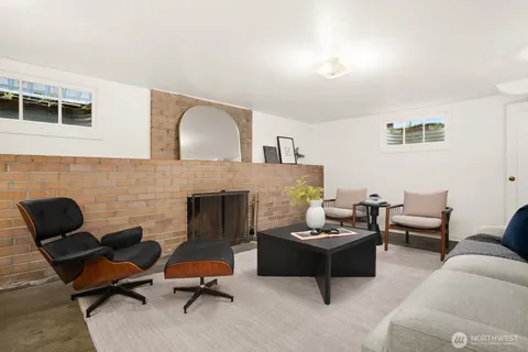 a living room with furniture mirror and a fireplace