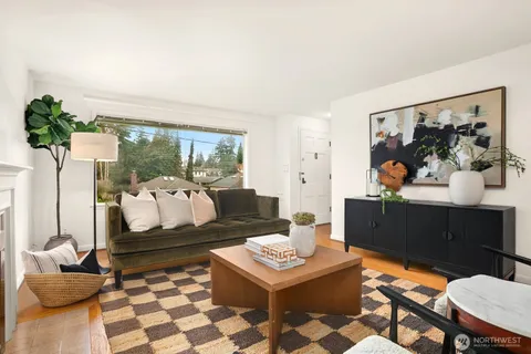 a living room with furniture and a painting on the wall