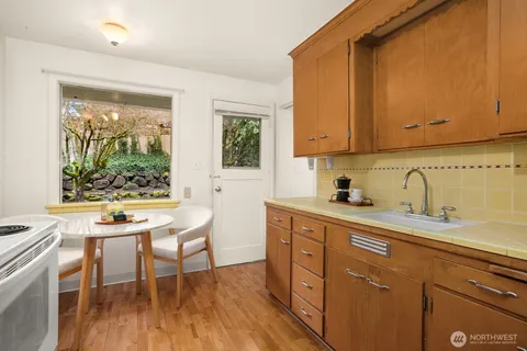 a kitchen with stainless steel appliances wooden cabinets a table and chairs in it