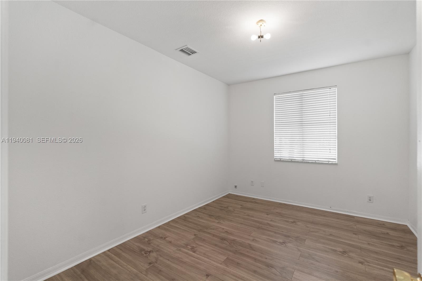 1564 Southwest 2nd Street Homestead, FL 33030 - Photo 14 of 29 an empty room with wooden floor and windows