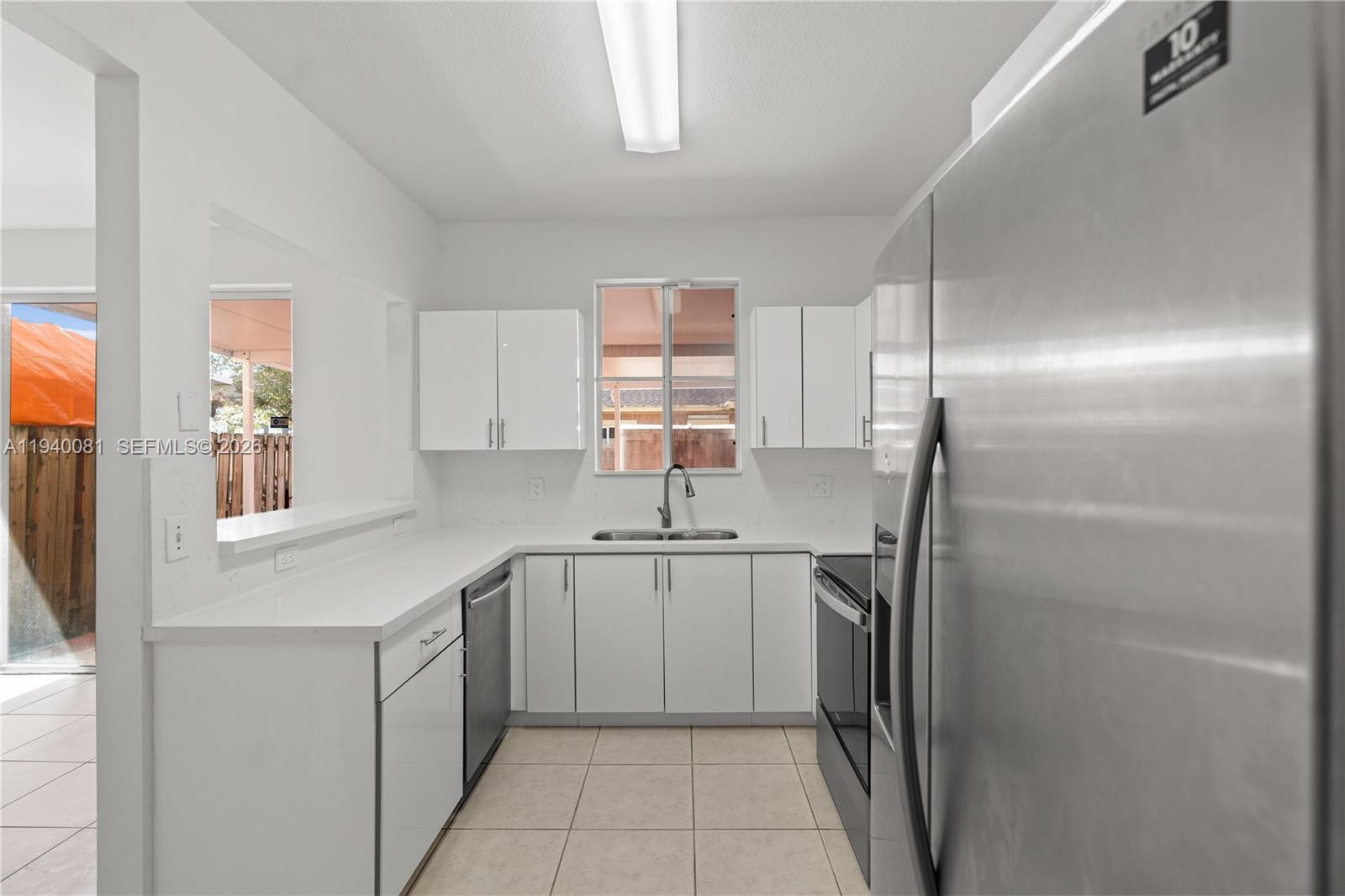 1564 Southwest 2nd Street Homestead, FL 33030 - Photo 7 of 29 a kitchen with a sink refrigerator and window
