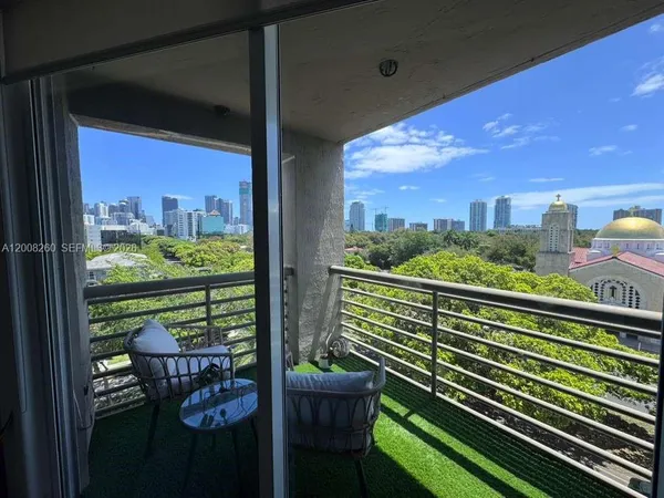 a city view from a balcony with outdoor seating