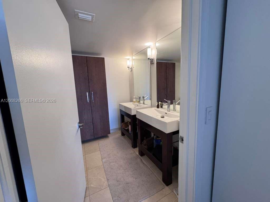 2400 Southwest 3rd Avenue, Unit 601 Miami, FL 33129 - Photo 12 of 21 a bathroom with a double vanity sink a and mirror