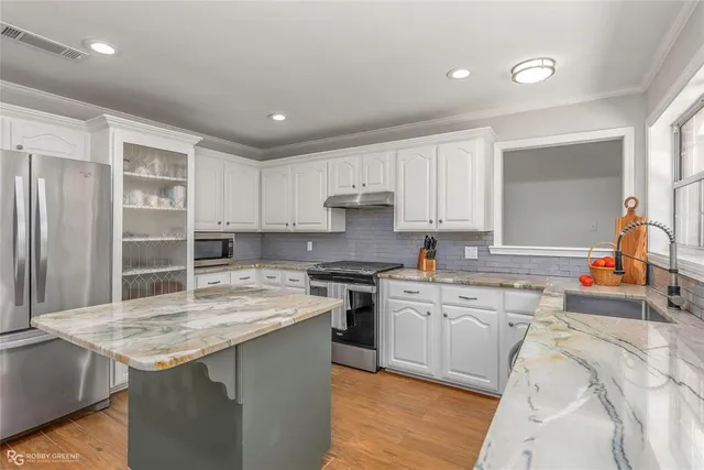 a kitchen with stainless steel appliances granite countertop a sink stove and refrigerator