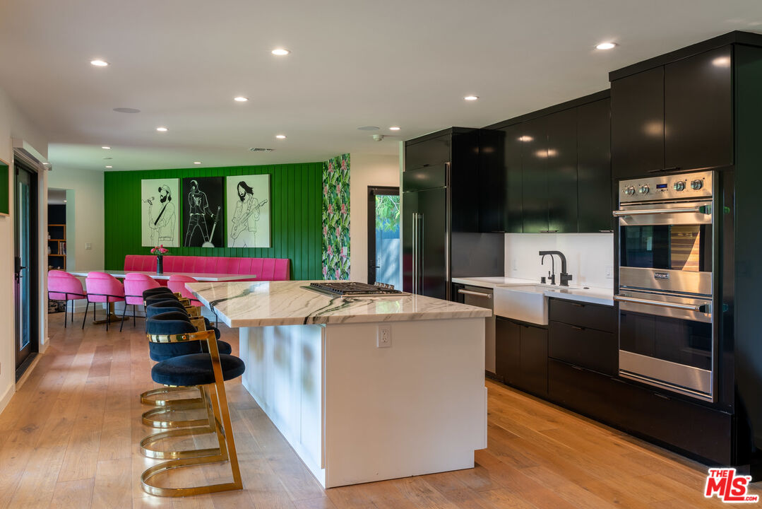 16666 Oldham Street Encino, CA 91436 - Photo 11 of 43 a kitchen with stainless steel appliances kitchen island granite countertop a stove and cabinets