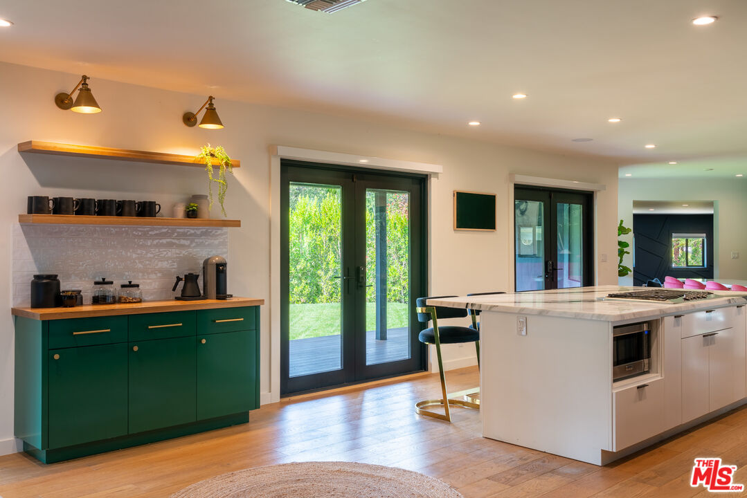 16666 Oldham Street Encino, CA 91436 - Photo 12 of 43 a kitchen with kitchen island a stove a refrigerator and a sink with wooden floor