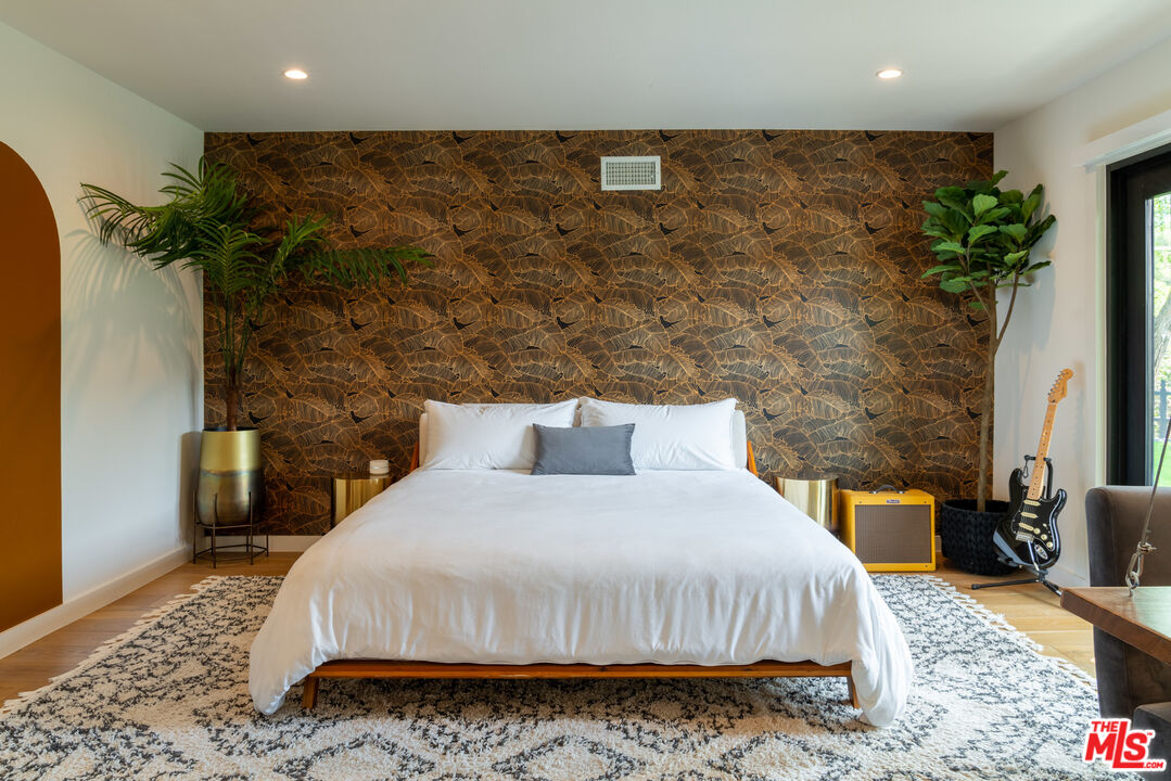 16666 Oldham Street Encino, CA 91436 - Photo 19 of 43 a bedroom with a bed and a potted plant