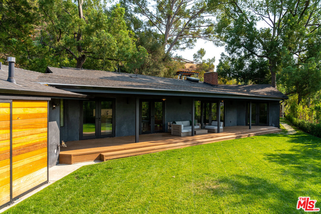 16666 Oldham Street Encino, CA 91436 - Photo 31 of 43 a view of a swimming pool with a table and chairs under an umbrella