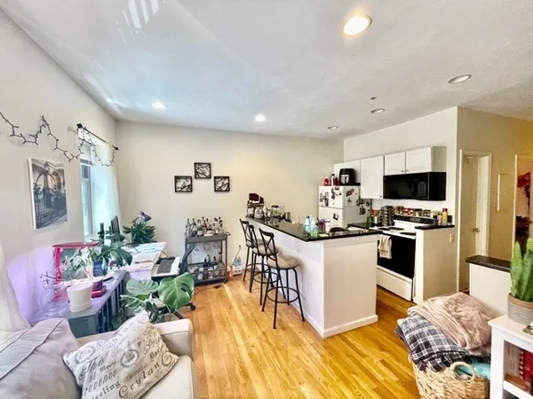 a kitchen with stainless steel appliances kitchen island granite countertop a refrigerator and a stove top oven