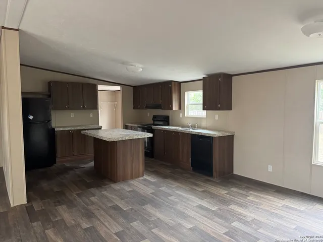 a large kitchen with a window and a sink