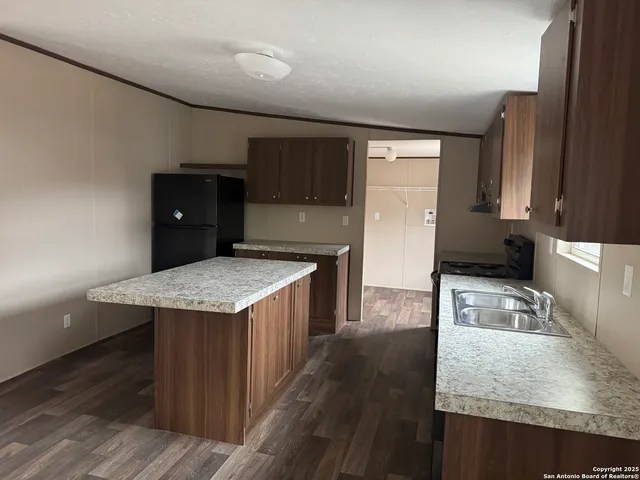 a kitchen with kitchen island sink refrigerator and stove
