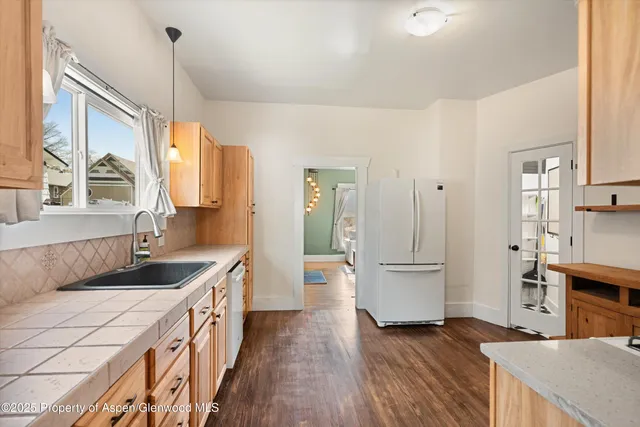 a kitchen with granite countertop a sink stove and refrigerator