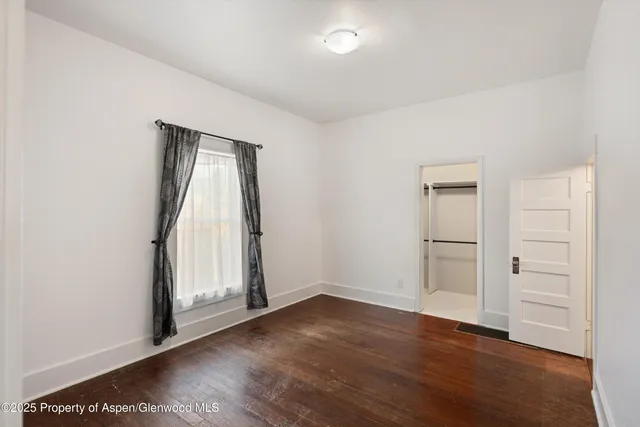 an empty room with wooden floor and closet