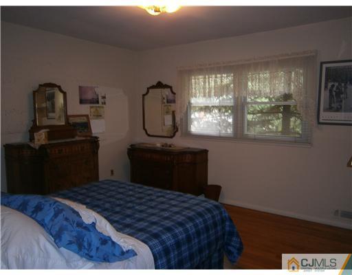 42 Clive Hills Road Edison, NJ 08820 - Photo 14 of 17 a bedroom with a bed and wooden floor
