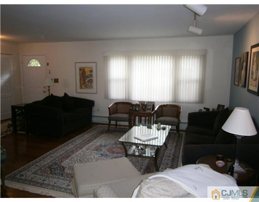 42 Clive Hills Road Edison, NJ 08820 - Photo 4 of 17 a living room with furniture a window and a lamp
