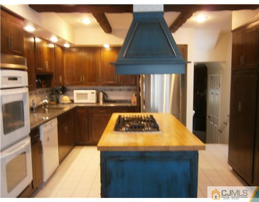 42 Clive Hills Road Edison, NJ 08820 - Photo 6 of 17 a kitchen with kitchen island granite countertop a sink a counter top space and stainless steel appliances