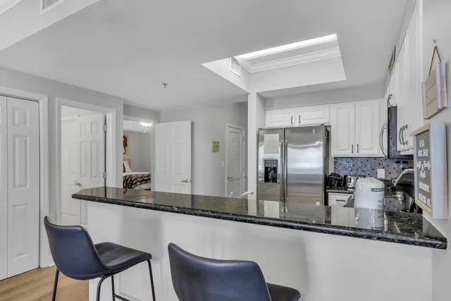 a kitchen with stainless steel appliances granite countertop a refrigerator and a stove top oven