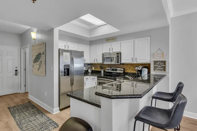 a kitchen with stainless steel appliances granite countertop a stove a refrigerator and a sink