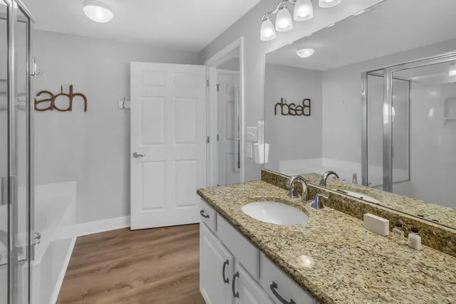 a bathroom with a granite countertop tub sink and shower