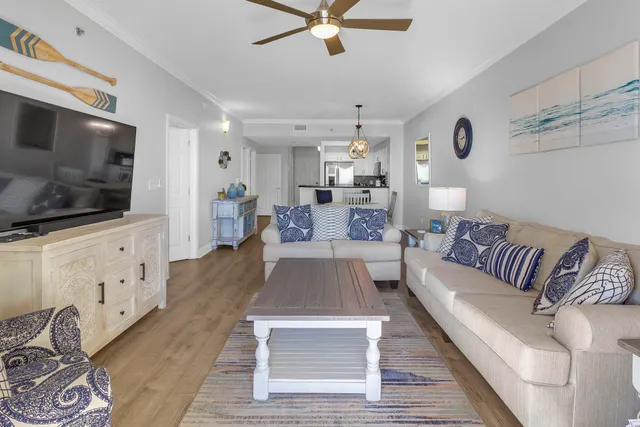 a living room with furniture ceiling fan and a large window