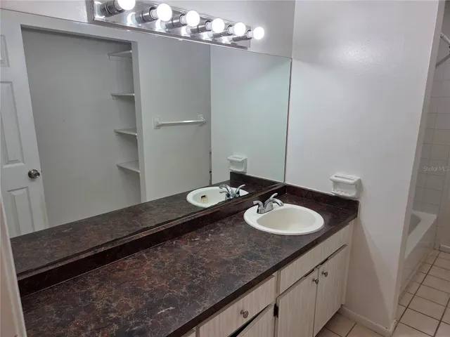 a bathroom with a granite countertop sink and a mirror