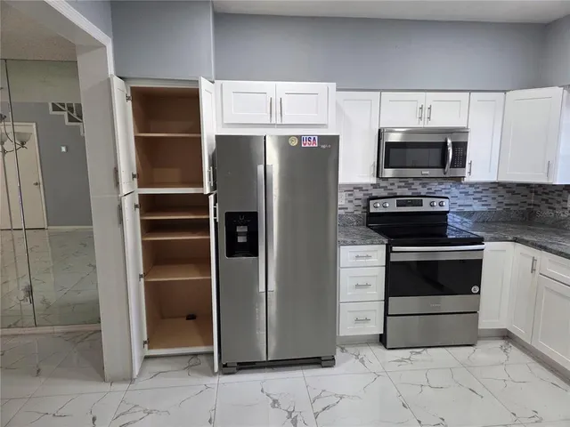 a kitchen with stainless steel appliances and cabinets