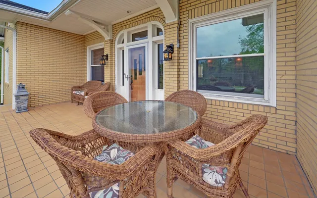 a view of a patio with table and chairs potted plants and a palm tree