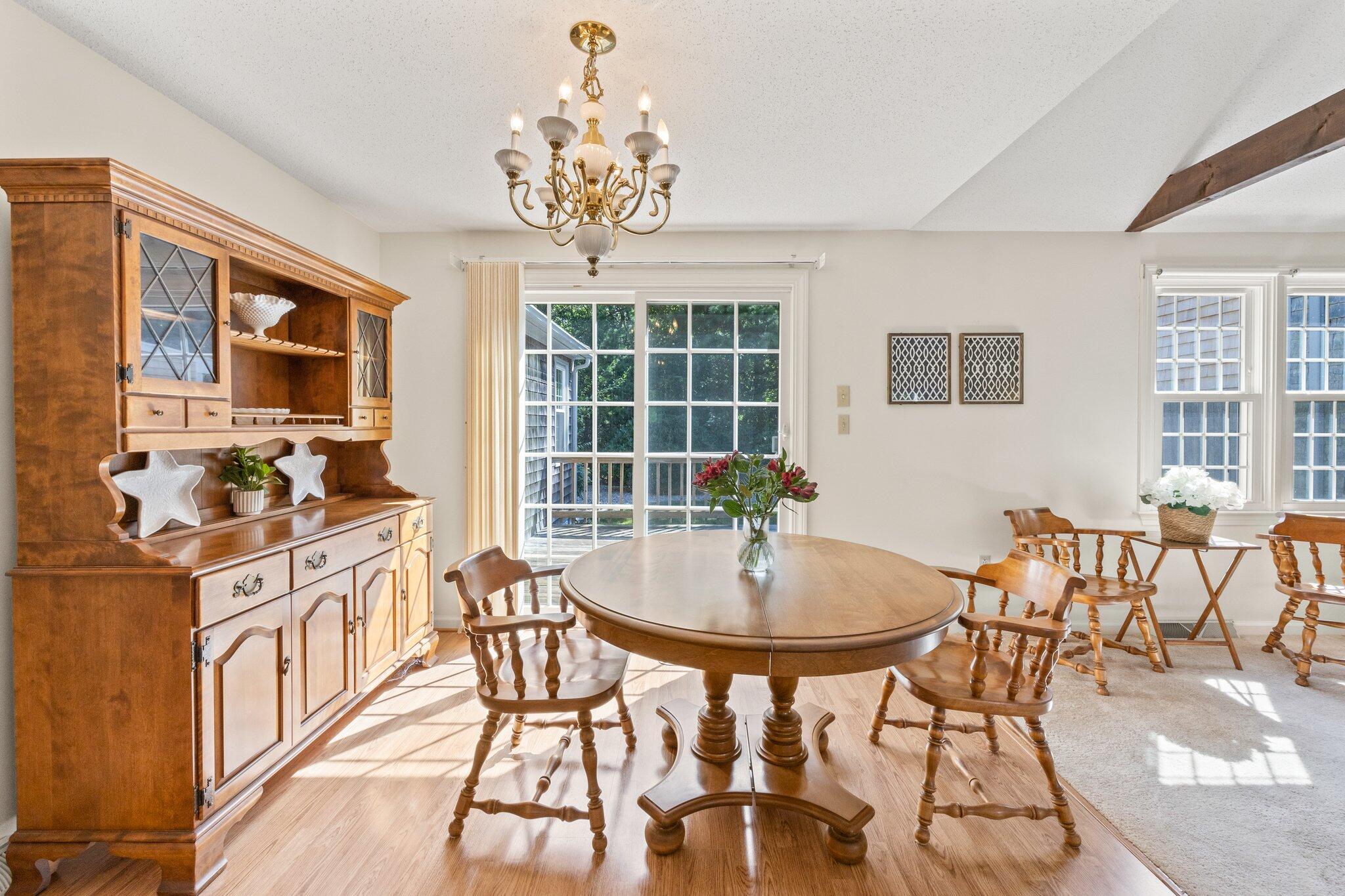 22 Debs Hill Road, Unit 6A Yarmouth Port, MA 02675 - Photo 5 of 30 a kitchen with stainless steel appliances a dining table and chairs with wooden floor