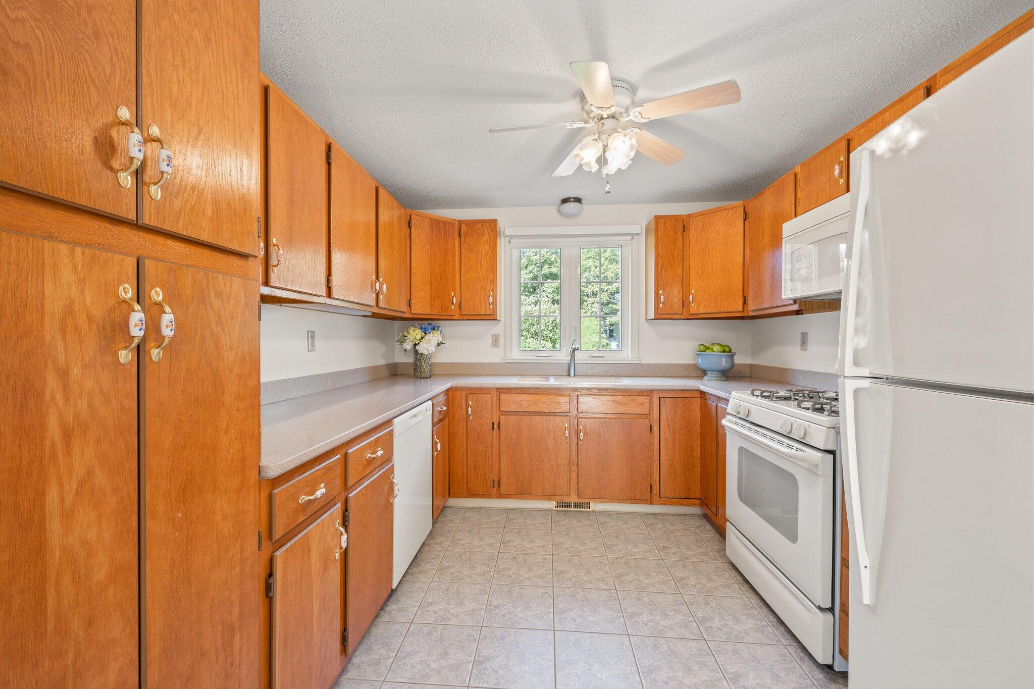 22 Debs Hill Road, Unit 6A Yarmouth Port, MA 02675 - Photo 6 of 30 a kitchen with stainless steel appliances granite countertop a refrigerator a sink dishwasher a stove and white countertops with wooden floor
