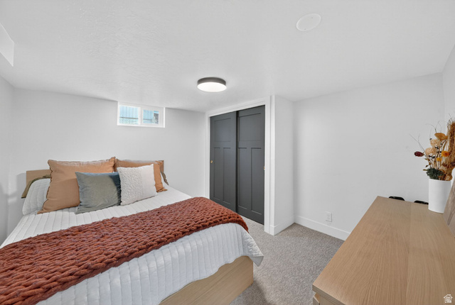 66 South 425 West Bountiful, UT 84010 - Photo 19 of 25 Bedroom featuring light gray carpeting, crisp white walls, a recessed window, black sliding closet doors, and a ceiling-mounted light fixture