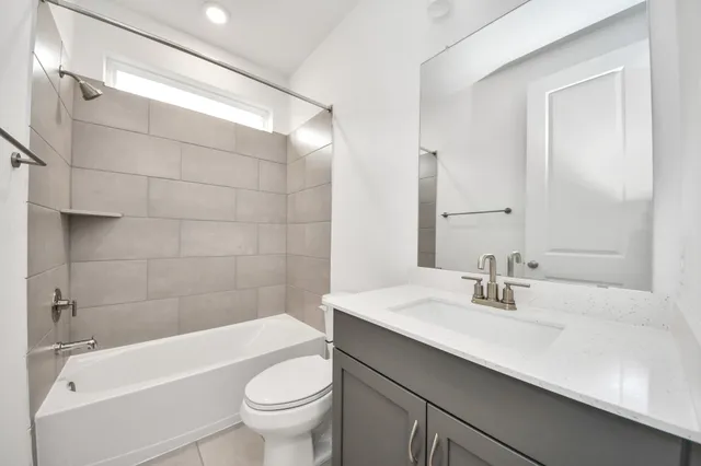 a bathroom with a sink a toilet a mirror a bathtub and shower